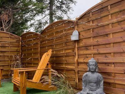 Jardin zen avec statue de Bouddha et chaise Adirondack