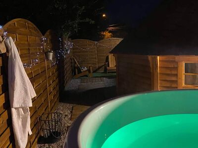 Bain nordique illuminé en vert dans le jardin la nuit
