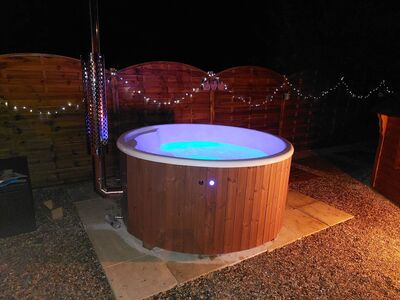 Bain nordique illuminé en bleu de nuit avec guirlandes lumineuses