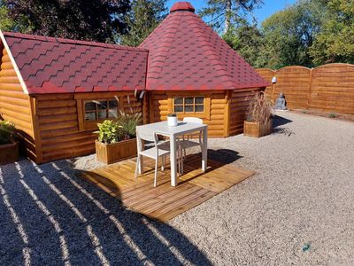 Kota finlandais en bois avec toit rouge et terrasse extérieure