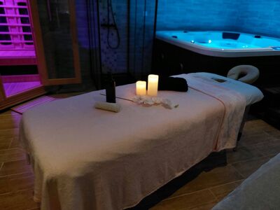 Table de massage avec bougies, jacuzzi et sauna infrarouge