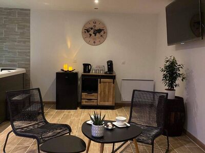 Espace détente du spa privatif avec fauteuils et jacuzzi