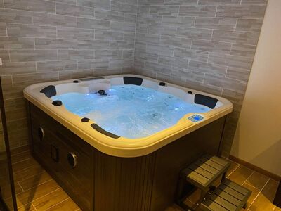 Jacuzzi privatif avec eau turquoise et éclairage LED