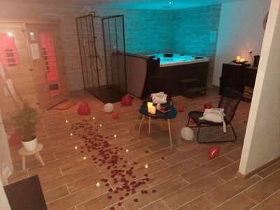 Spa privatif romantique avec jacuzzi, sauna et pétales de roses