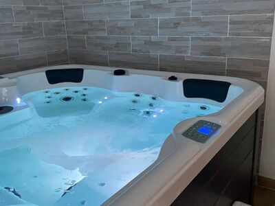 Jacuzzi intérieur avec éclairage bleu et panneau de commande