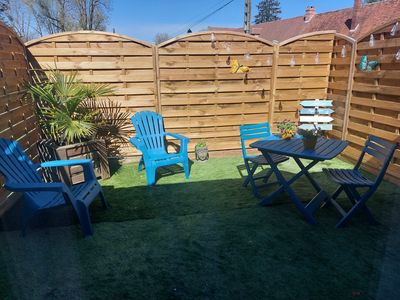 Terrasse privée avec mobilier bleu et clôture en bois