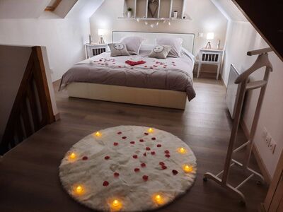 Chambre romantique sous combles avec pétales de roses et bougies